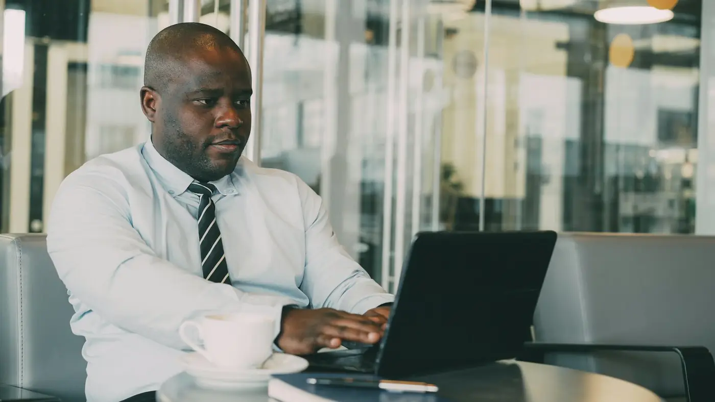 A professional reviewing onboarding documents at a laptop