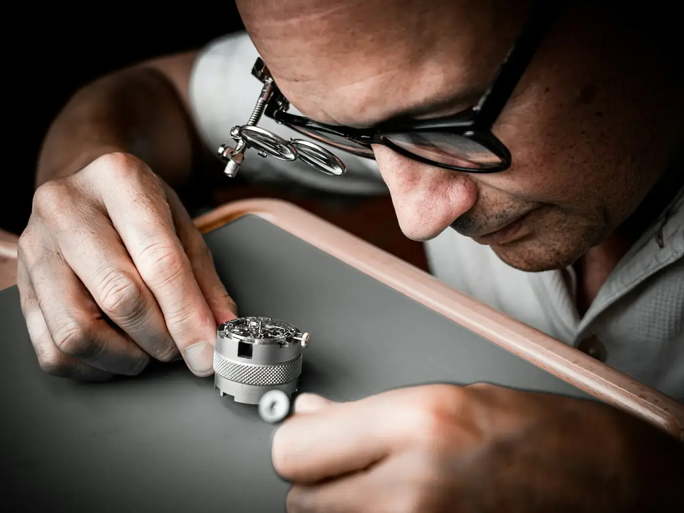 A specialist examining an item through a loupe
