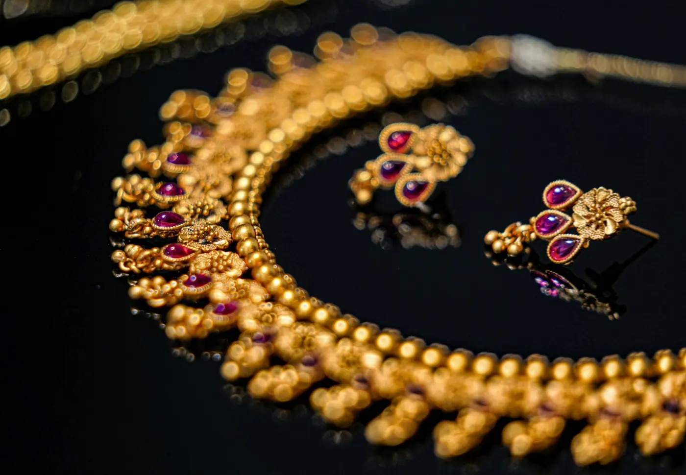 Gold necklace and earrings set with gemstones