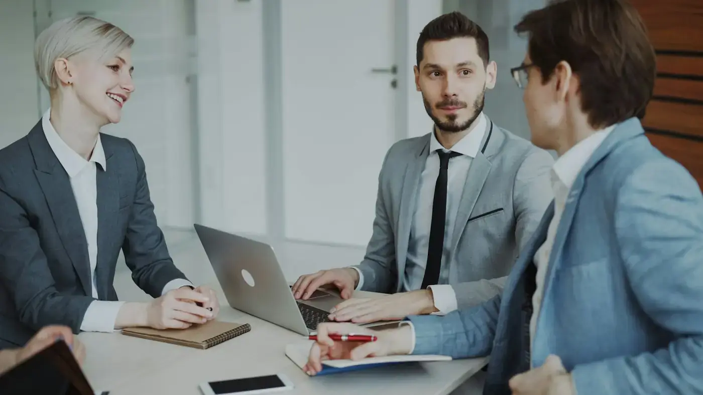 A team discussing figures on a laptop